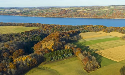 Am aerial view of a gorge, farmland, and a lake