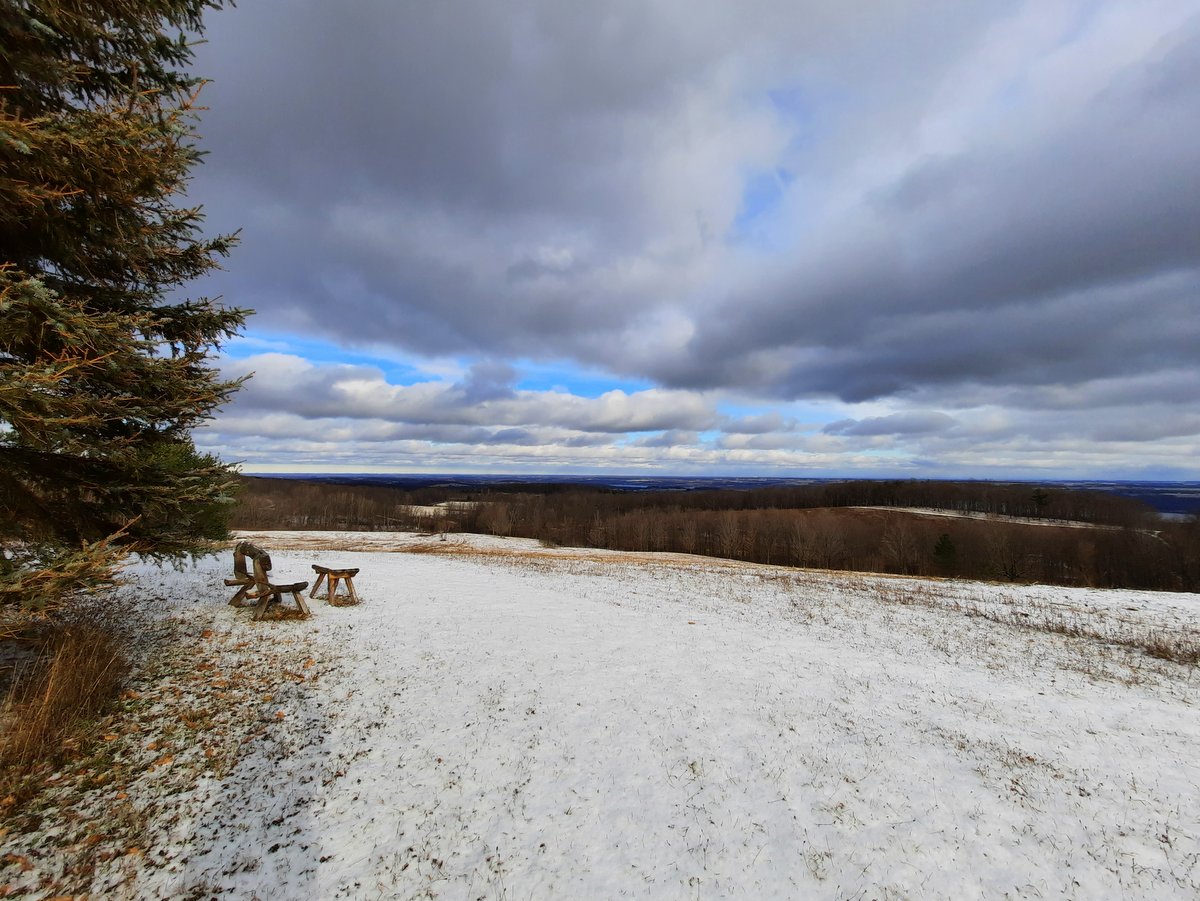 A wooden bench overlooking a snow-covered field
