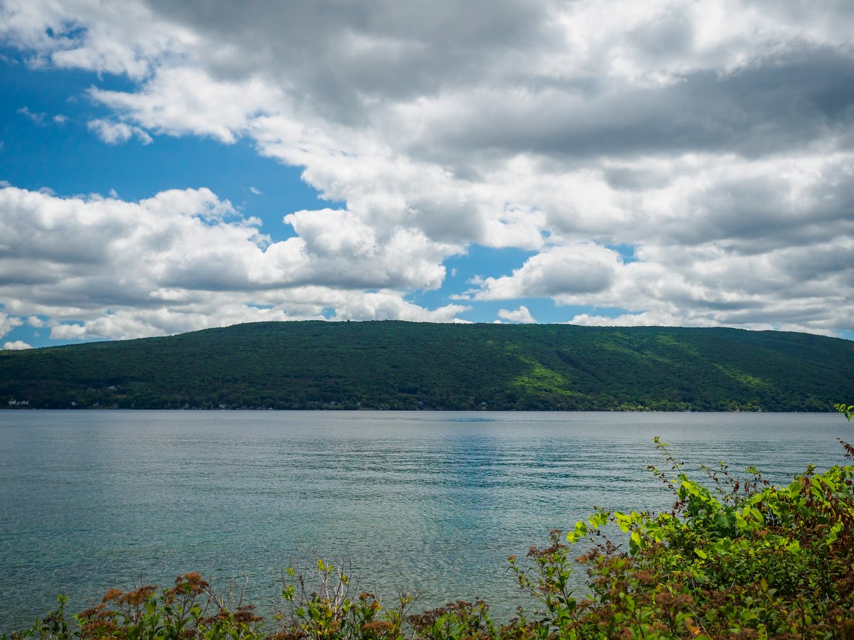 A blue lake with green hills in the background