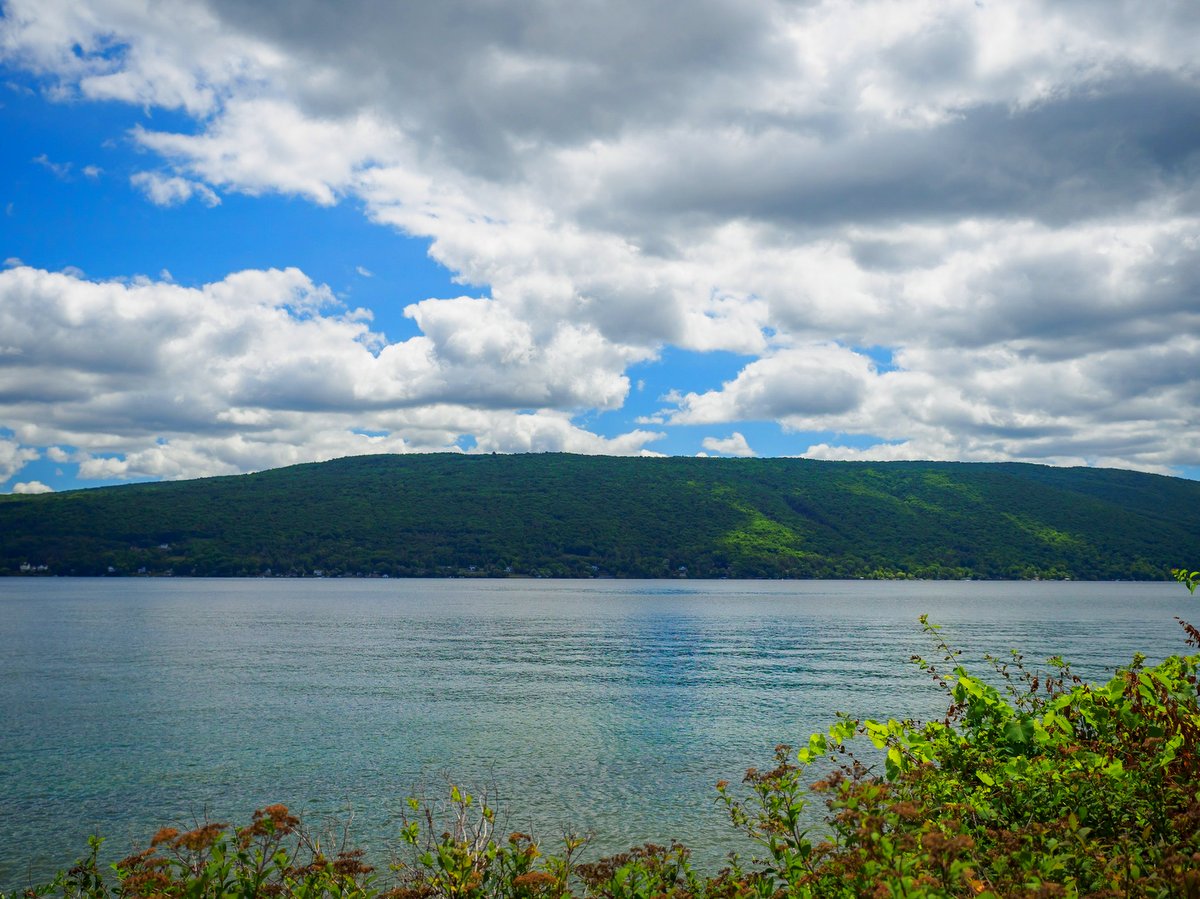 A green hill with a blue lake in the foreground