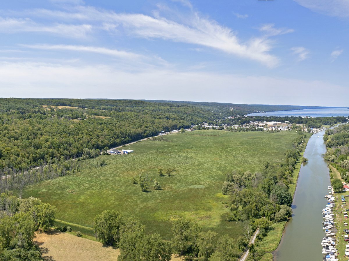 A wetland area and canal with a lake in the background