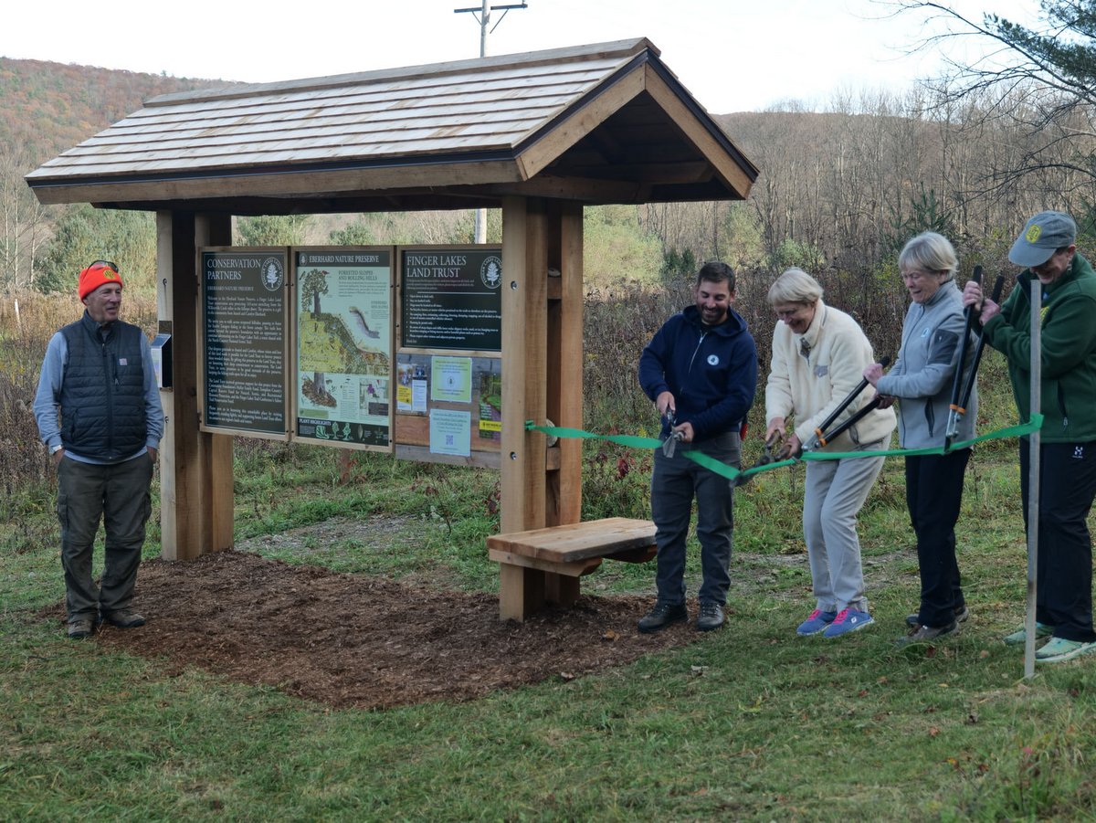 People cutting a ribbon at a nature preserve opening ceremony