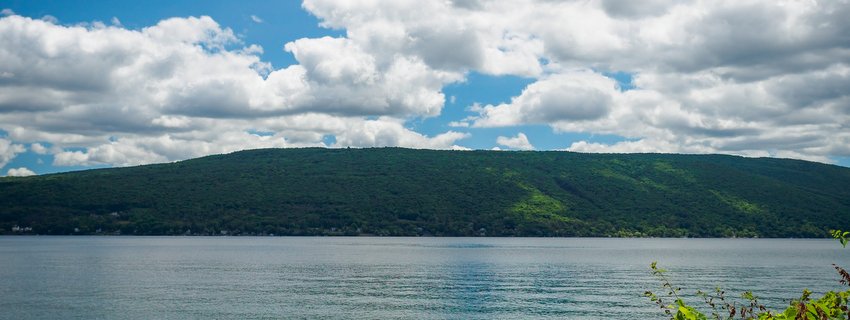 A green hillside with a blue lake in the foreground