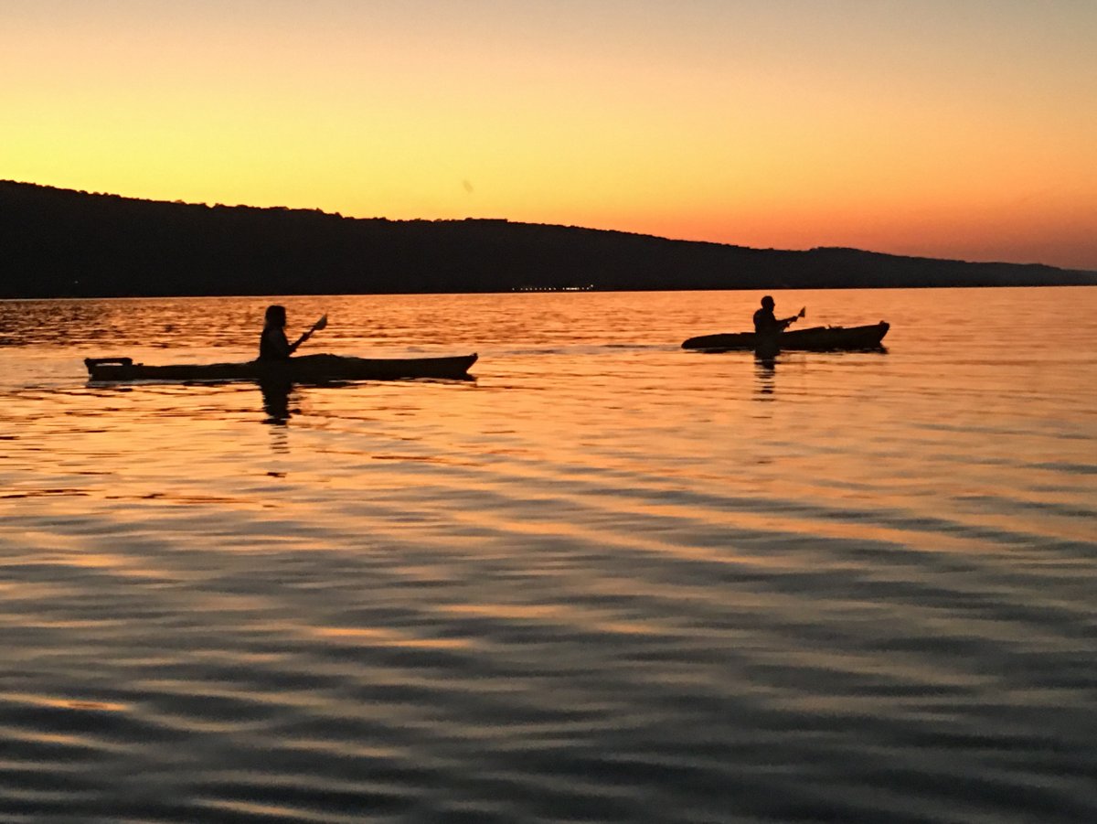 Two people kayaking at sunset