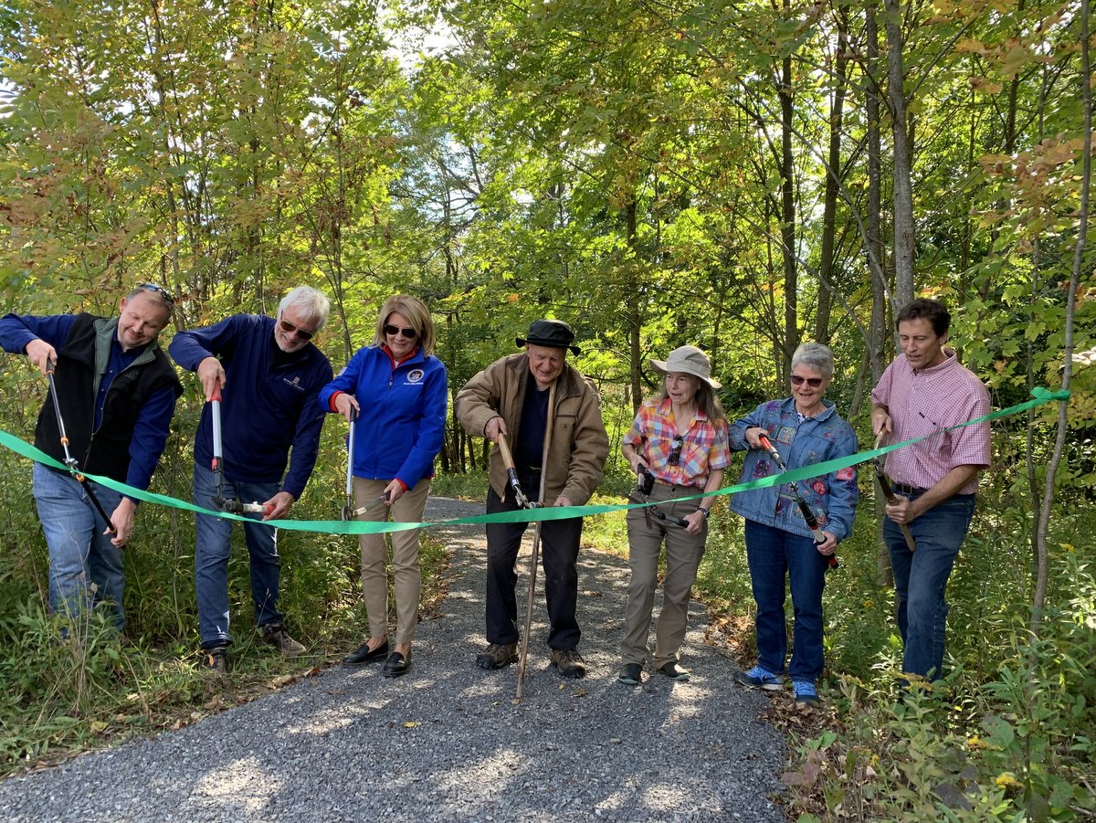People cutting a ribbon at a nature preserve opening ceremony