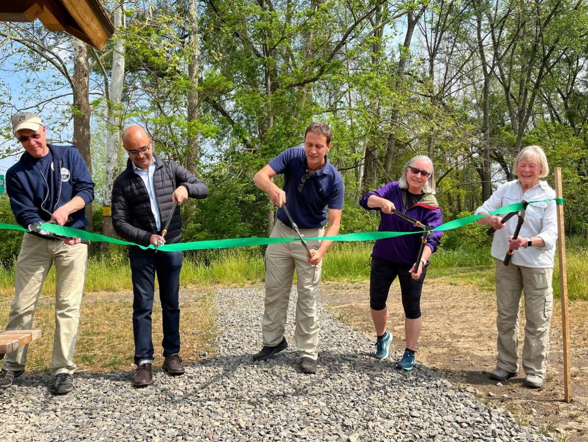 People cutting a ribbon at a nature preserve dedication ceremony