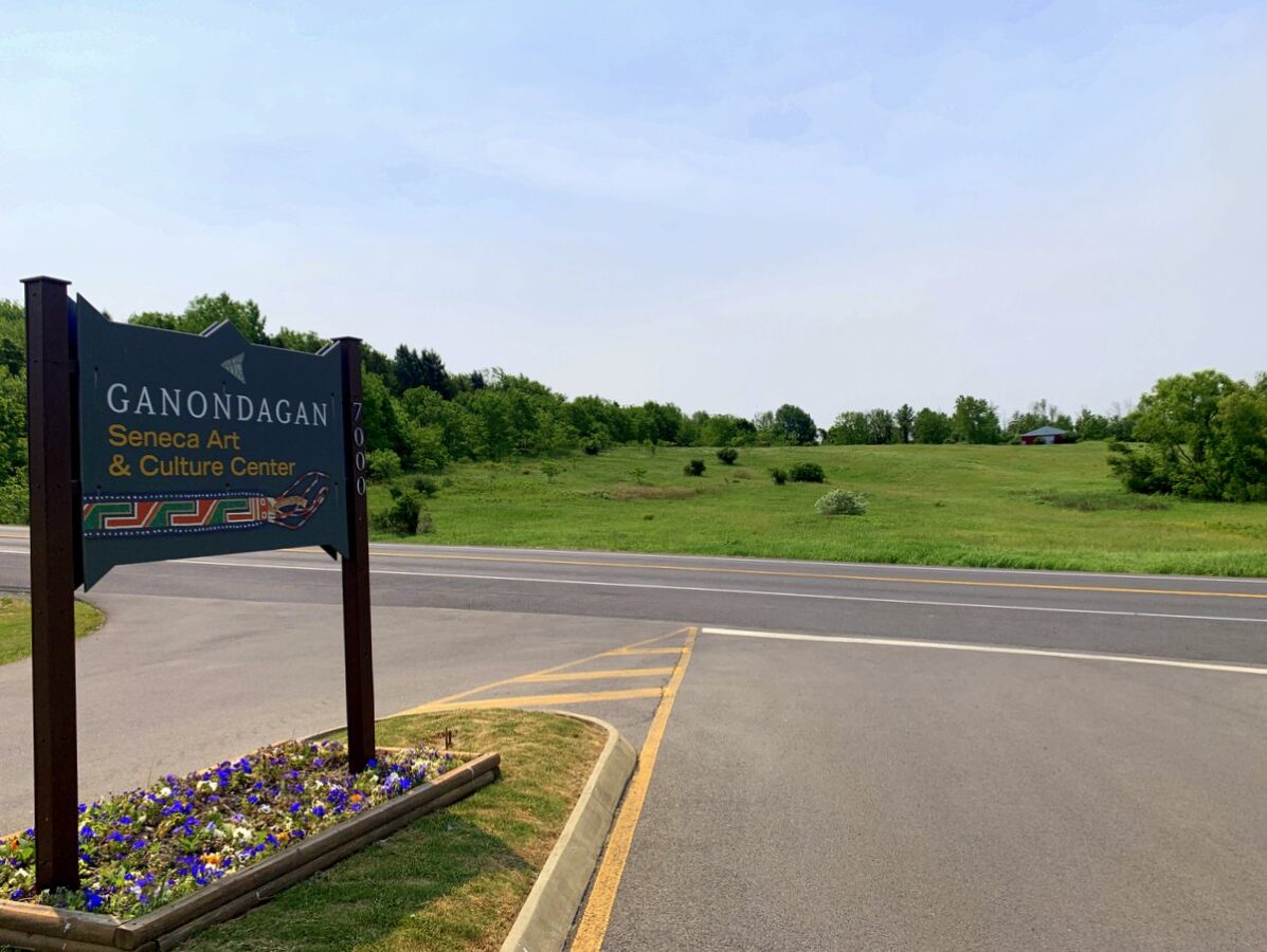 A view from the entrance to a historic site, looking at a field