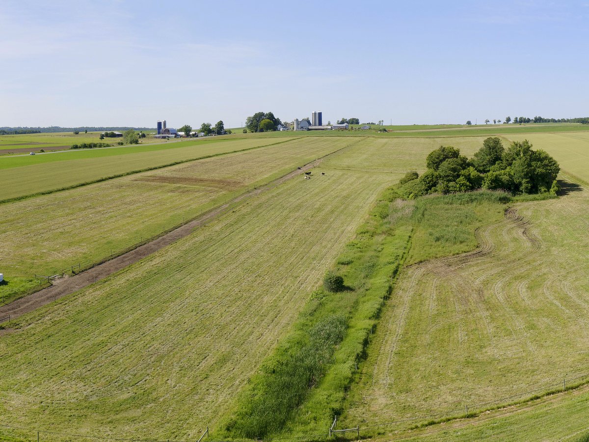 Farm fields with farm buildings in the distance 