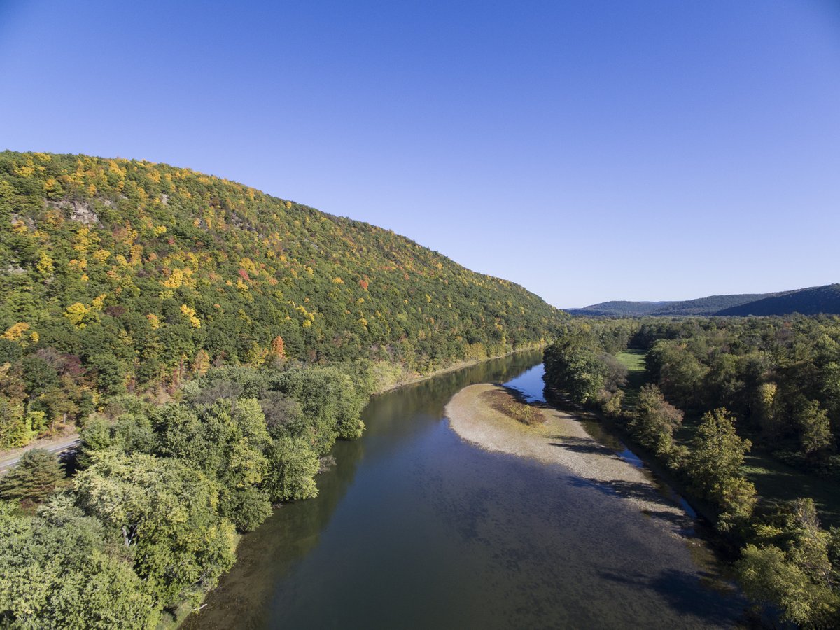 A river bordered by green hills