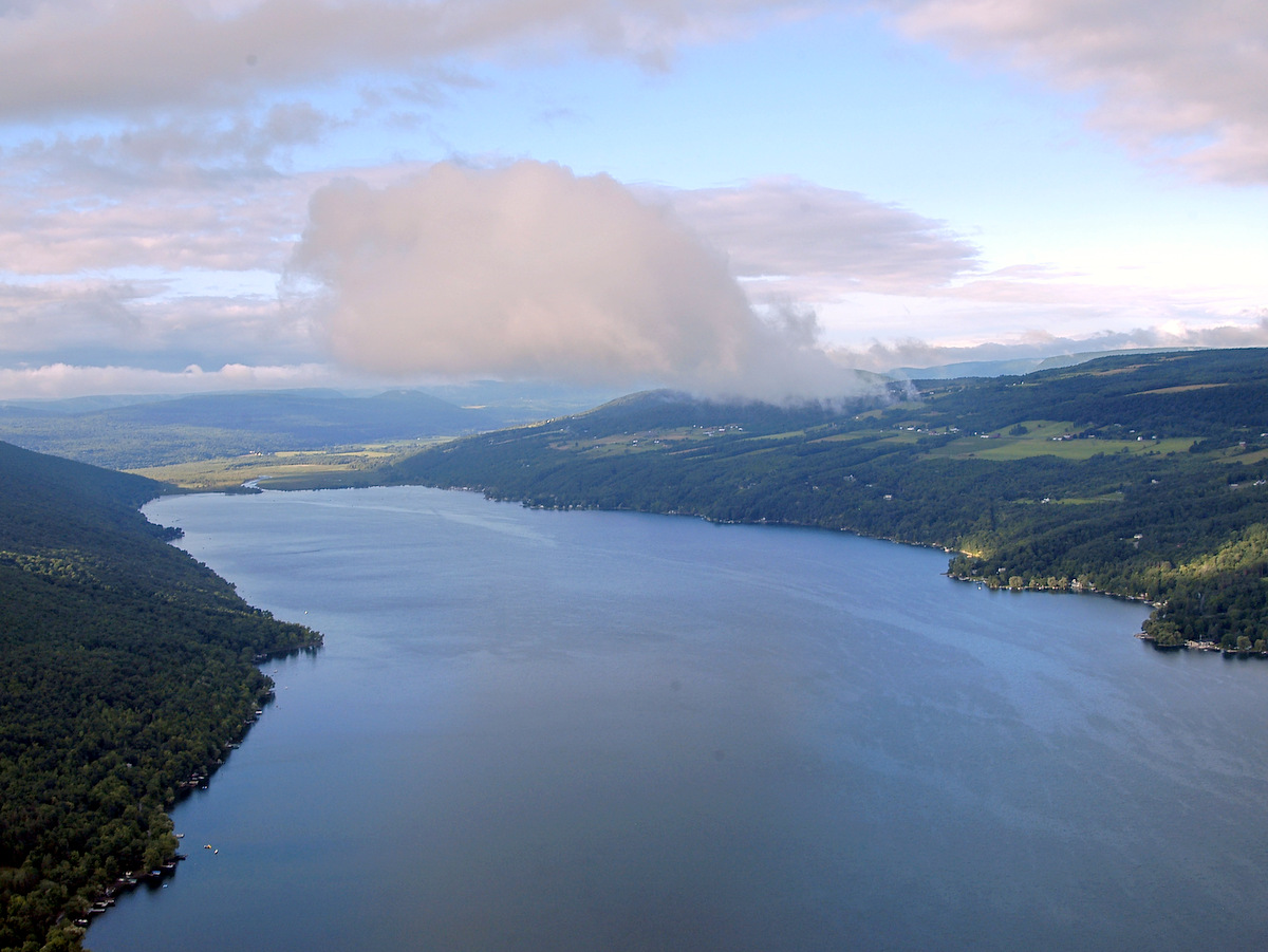 An aerial view of a lake with low-hanging clouds