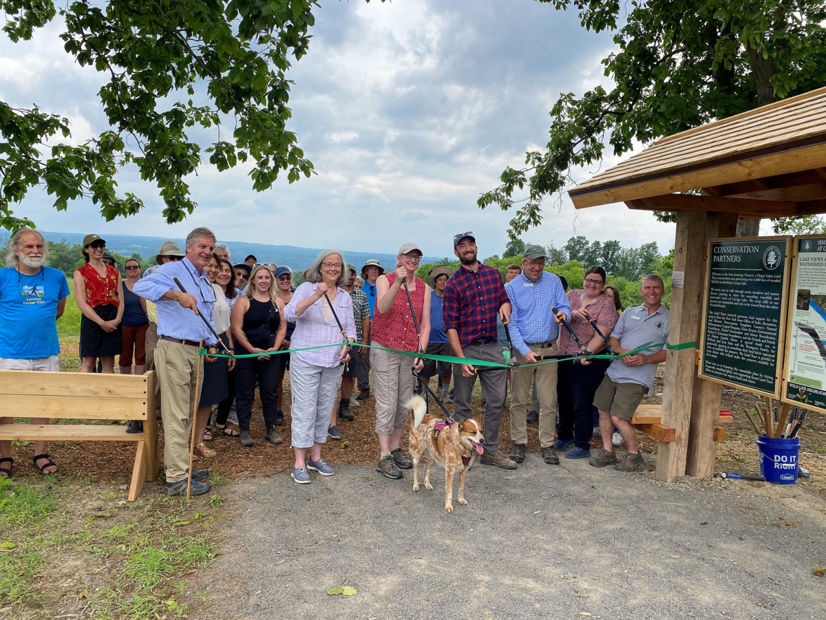 A group of people cutting a ribbon to celebrate the opening of a new nature preserve
